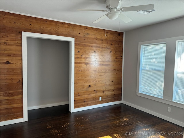 218 SW B, Ardmore, OK 73401 - unfurnished room with wood walls, healthy amount of natural light, a ceiling fan, dark wood-type flooring, and baseboards