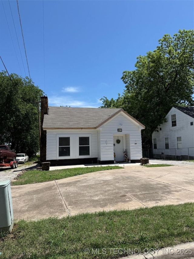 218 SW B, Ardmore, OK 73401 - view of front of home featuring a chimney, fence, and roof with shingles