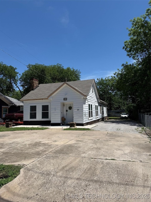 218 SW B, Ardmore, OK 73401 - bungalow-style home featuring concrete driveway, a chimney, and fence