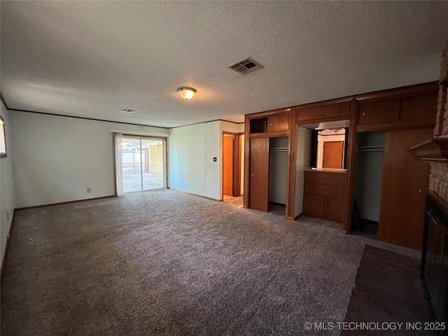 1421 E 50th St S, Tulsa, OK 74105 - unfurnished bedroom with a textured ceiling, baseboards, a fireplace, carpet flooring, and multiple closets
