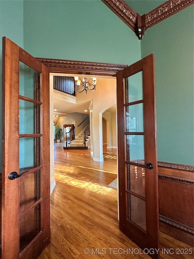 10213 S 88th E Ave, Tulsa, OK 74133 - hall with arched walkways, wood finished floors, stairway, and a chandelier