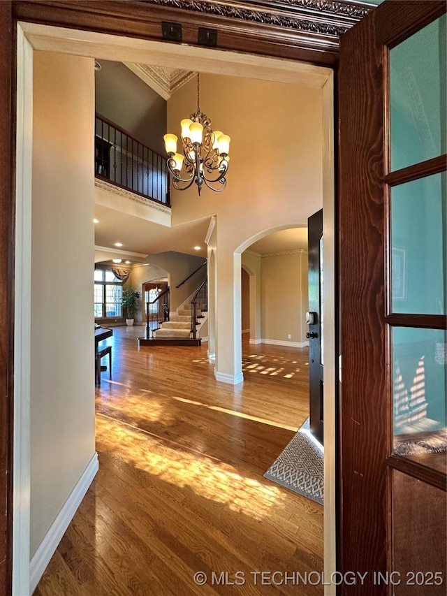 10213 S 88th E Ave, Tulsa, OK 74133 - foyer entrance with arched walkways, a chandelier, wood finished floors, stairway, and a towering ceiling
