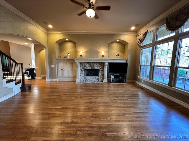 10213 S 88th E Ave, Tulsa, OK 74133 - unfurnished living room featuring arched walkways, ceiling fan, wood finished floors, ornamental molding, and a premium fireplace
