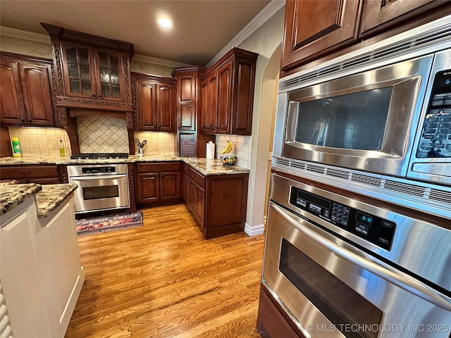 10213 S 88th E Ave, Tulsa, OK 74133 - kitchen featuring stainless steel appliances, crown molding, light wood-style floors, light stone counters, and decorative backsplash