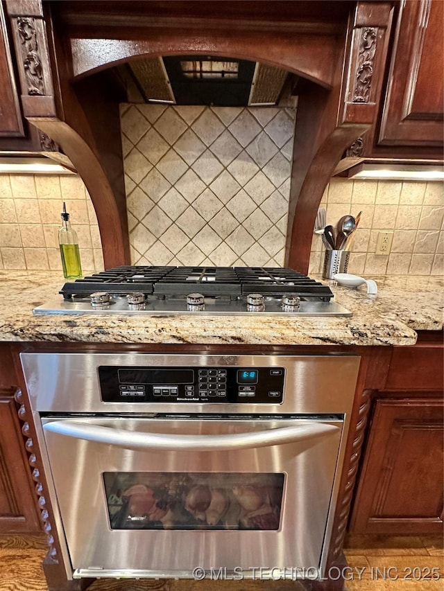 10213 S 88th E Ave, Tulsa, OK 74133 - kitchen featuring appliances with stainless steel finishes, decorative backsplash, and light stone countertops