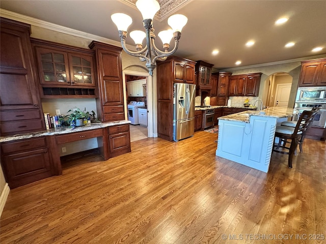 10213 S 88th E Ave, Tulsa, OK 74133 - kitchen featuring stainless steel appliances, a chandelier, crown molding, a breakfast bar area, and arched walkways