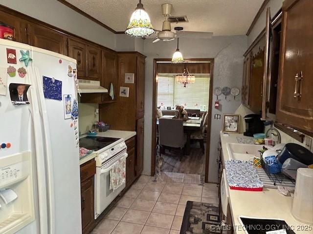 901 S Anthony St, Muskogee, OK 74403 - kitchen with white appliances, a sink, light countertops, light tile patterned floors, and a textured ceiling