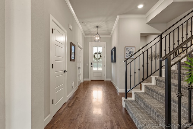 foyer featuring baseboards, dark wood-style floors, stairway, a notable chandelier, and crown molding