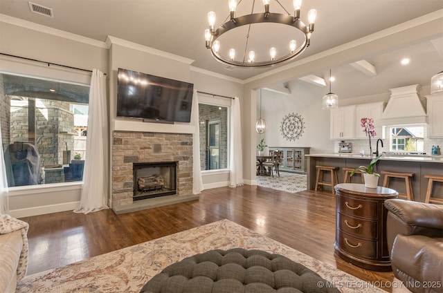 living area featuring dark wood-style floors, an inviting chandelier, visible vents, and baseboards