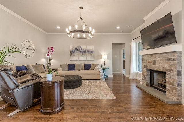 living room with dark wood-style floors, baseboards, an inviting chandelier, ornamental molding, and a fireplace