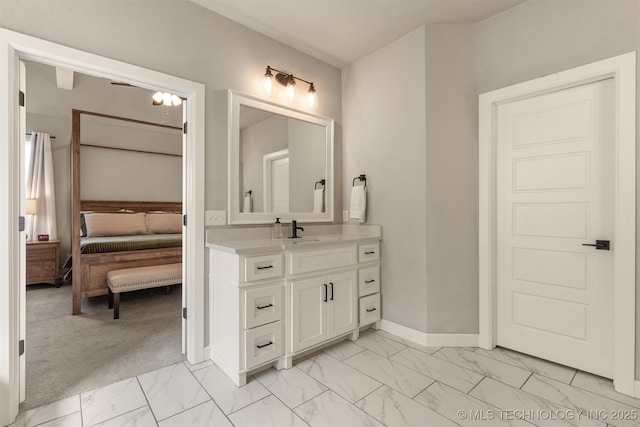 bathroom featuring ensuite bathroom, marble finish floor, vanity, and baseboards