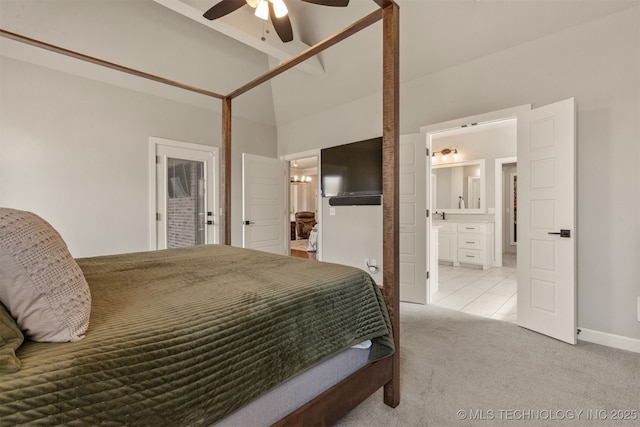bedroom with lofted ceiling, ensuite bathroom, baseboards, light carpet, and a ceiling fan