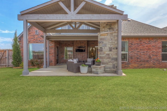 rear view of property with a patio, brick siding, fence, and a yard