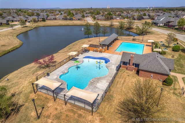 pool featuring fence, a residential view, and a water view