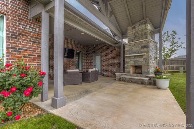 view of patio featuring fence and an outdoor living space with a fireplace