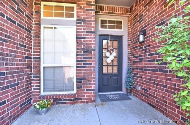 view of exterior entry with brick siding