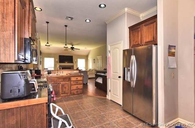 kitchen featuring open floor plan, brown cabinets, a ceiling fan, and stainless steel refrigerator with ice dispenser