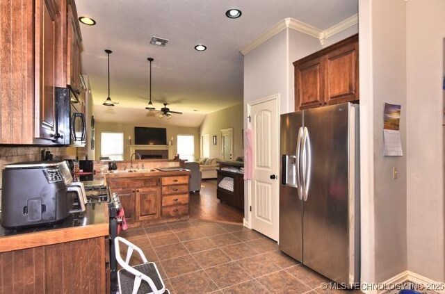 4705 S 178th E Ave, Tulsa, OK 74134 - kitchen with stainless steel fridge, a ceiling fan, open floor plan, brown cabinets, and crown molding