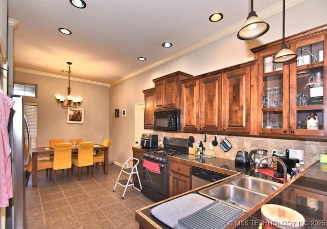 kitchen with pendant lighting, an inviting chandelier, black appliances, a sink, and dark countertops