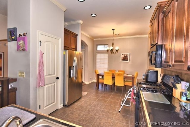 kitchen with arched walkways, an inviting chandelier, ornamental molding, stainless steel appliances, and pendant lighting
