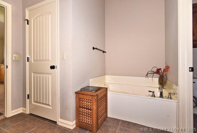bathroom with a bath, baseboards, and tile patterned flooring