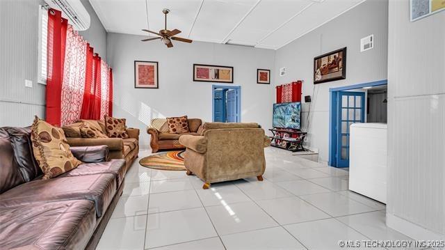 13760 SW Wilderness, Kingston, OK 73439 - living area with light tile patterned floors, ceiling fan, visible vents, and a wall mounted air conditioner