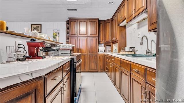 13760 SW Wilderness, Kingston, OK 73439 - kitchen featuring light tile patterned floors, light countertops, visible vents, stainless steel range with electric cooktop, and a sink