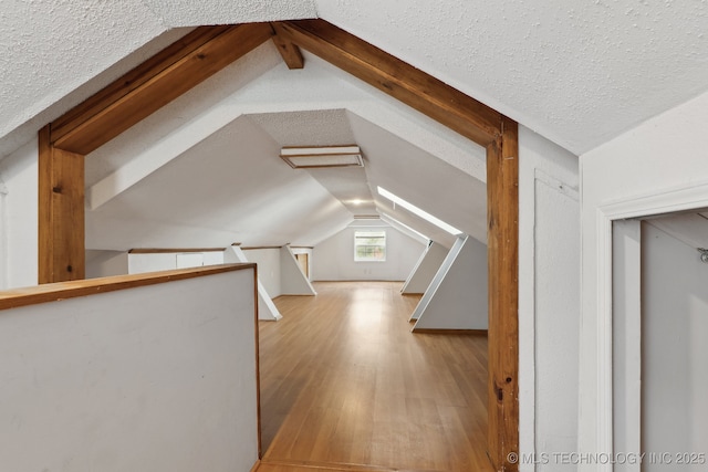 204 S Jamestown Ave, Tulsa, OK 74112 - additional living space featuring vaulted ceiling, wood finished floors, and a textured ceiling