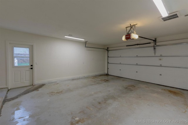 garage featuring visible vents, baseboards, and a garage door opener