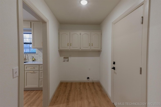 laundry room with baseboards, washer hookup, light wood-style floors, hookup for an electric dryer, and cabinet space