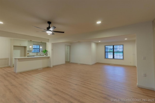 unfurnished living room with light wood finished floors, ceiling fan, baseboards, and recessed lighting