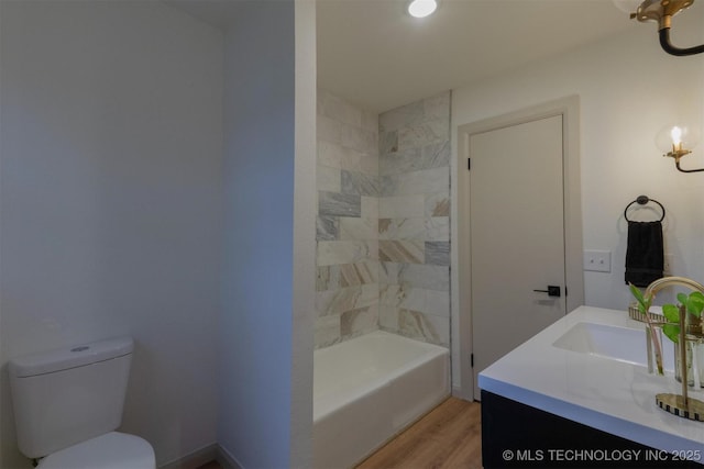 bathroom featuring shower / washtub combination, vanity, toilet, and wood finished floors