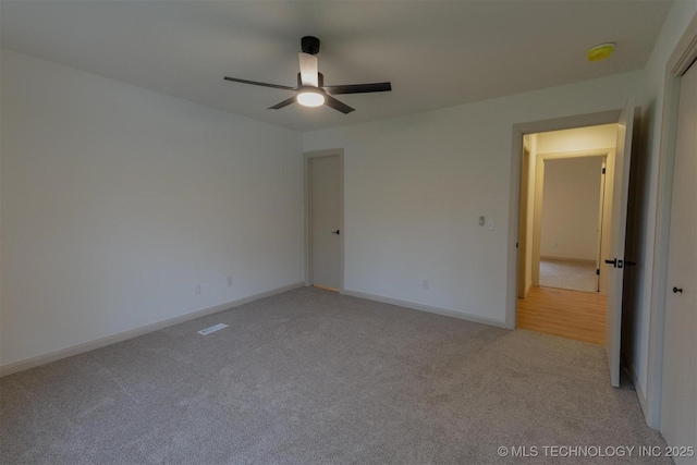 unfurnished bedroom with light carpet, baseboards, and a ceiling fan