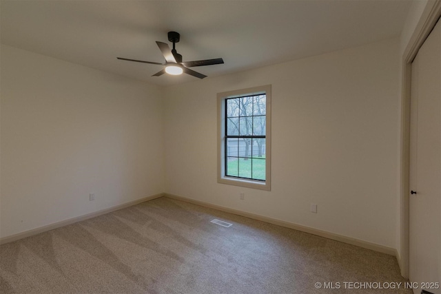 unfurnished room with visible vents, ceiling fan, light carpet, and baseboards