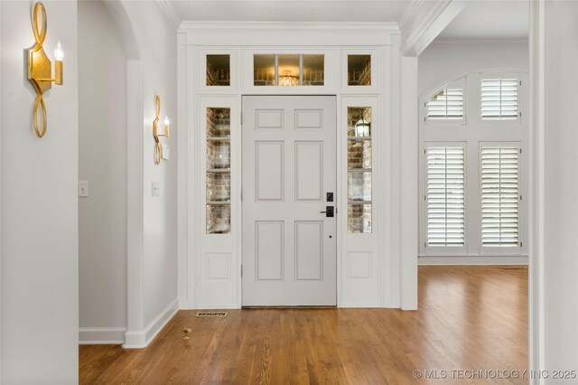 5815 S Knoxville Ave, Tulsa, OK 74135 - entrance foyer with ornamental molding, baseboards, arched walkways, and wood finished floors
