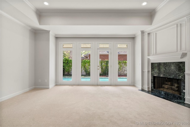 5815 S Knoxville Ave, Tulsa, OK 74135 - unfurnished living room with baseboards, a raised ceiling, a high end fireplace, crown molding, and carpet flooring