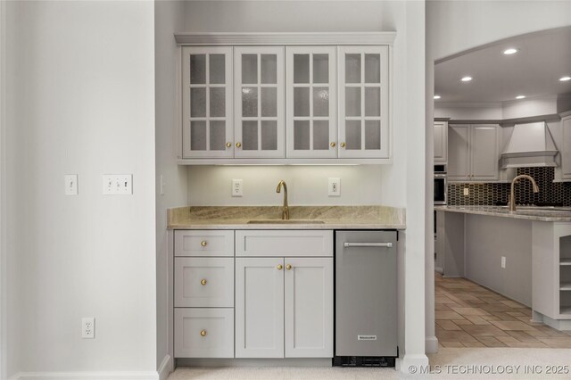 5815 S Knoxville Ave, Tulsa, OK 74135 - bar featuring custom range hood, decorative backsplash, a sink, and stainless steel oven