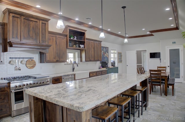 kitchen featuring light stone counters, tasteful backsplash, appliances with stainless steel finishes, a center island, and ornamental molding