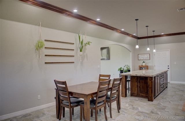 dining space with baseboards, recessed lighting, ornamental molding, and arched walkways