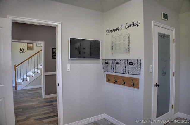 interior space with baseboards, wood finished floors, and stairs