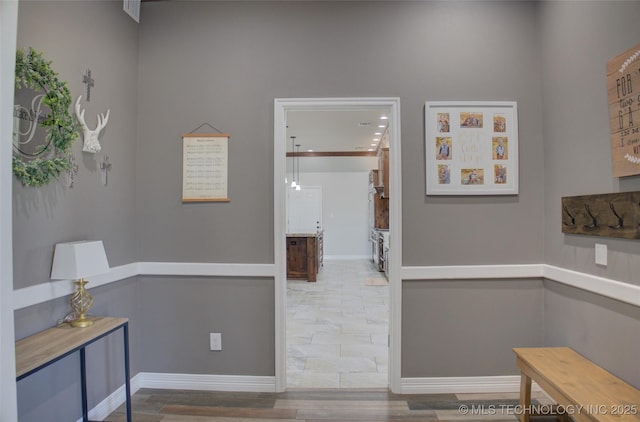 corridor featuring wood finished floors and baseboards
