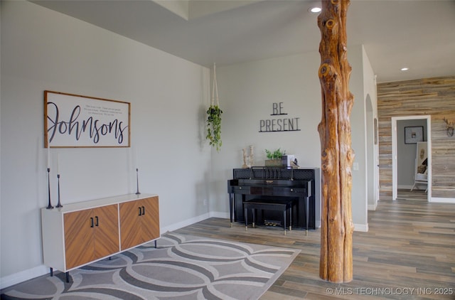 sitting room with wood finished floors, baseboards, recessed lighting, and arched walkways