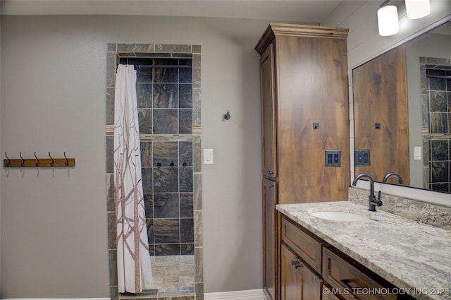 full bath featuring a tile shower and vanity