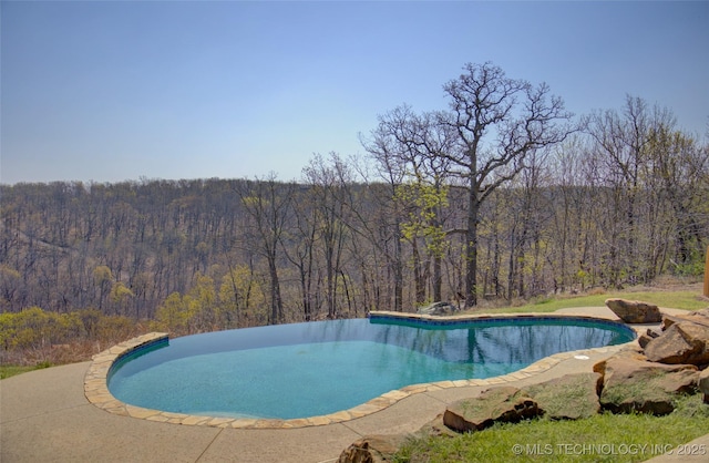 outdoor pool featuring a view of trees