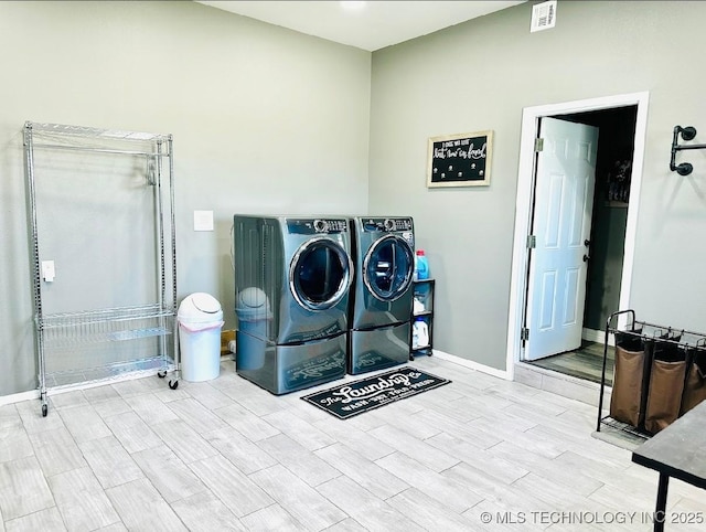 laundry area featuring laundry area, washer and dryer, baseboards, visible vents, and wood tiled floor