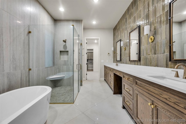 bathroom with tile walls, a soaking tub, a sink, and a stall shower