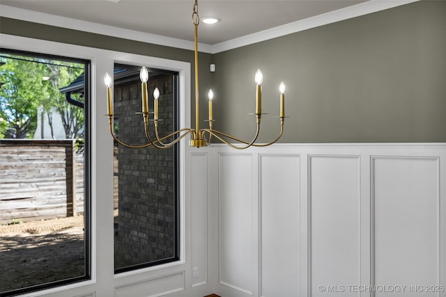 doorway with a decorative wall, a notable chandelier, and a wainscoted wall