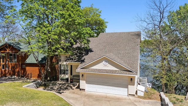 view of front of property with a garage, driveway, a shingled roof, and a front lawn