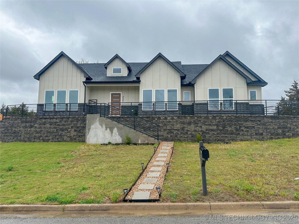 425 E 48th Ct, Sand Springs, OK 74063 - view of front of house with a front yard and board and batten siding