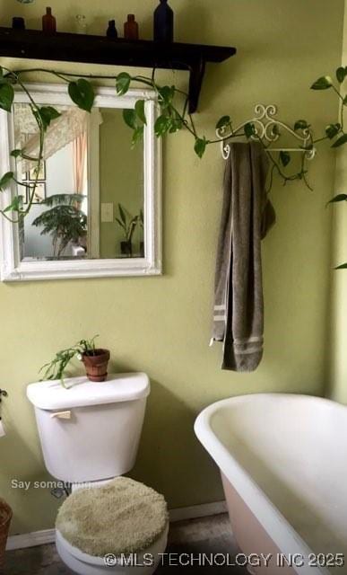 405 N Industrial Ave, Sand Springs, OK 74063 - bathroom featuring baseboards, toilet, and a soaking tub